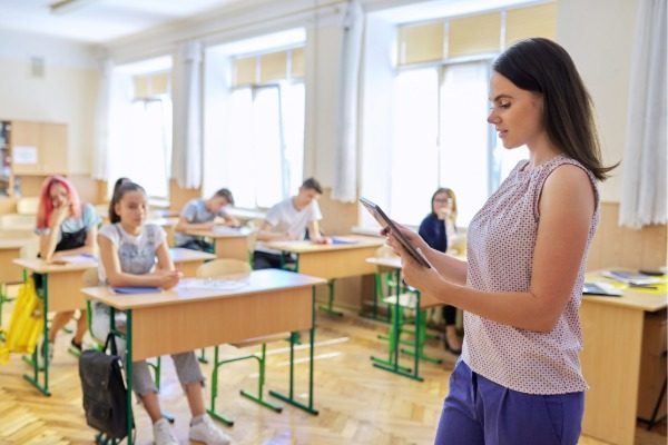 Lehrerin präsentiert Inhalte vor Schülern in einem Klassenzimmer.